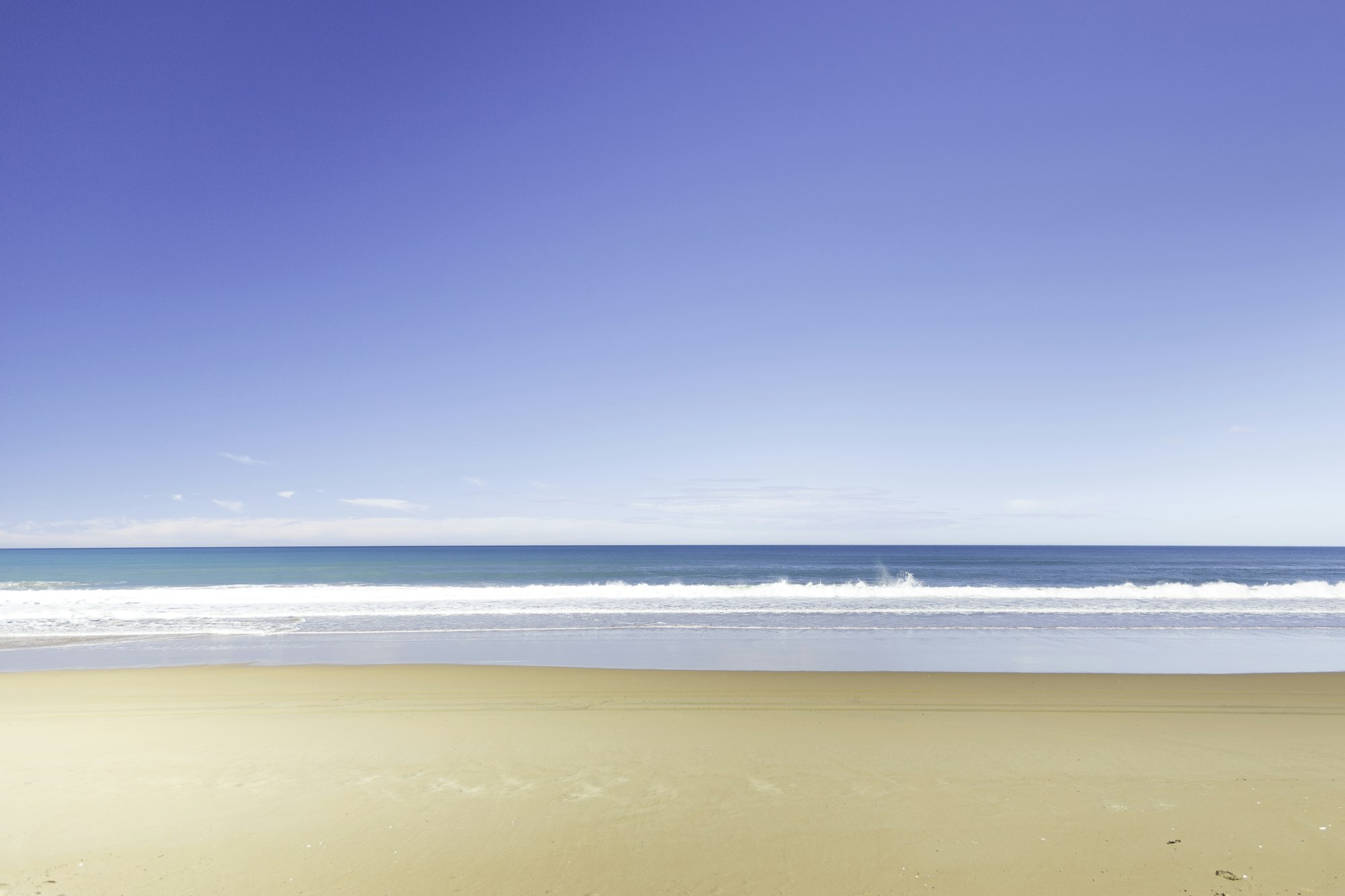 Bright sandy beach and blue ocean on a summer day