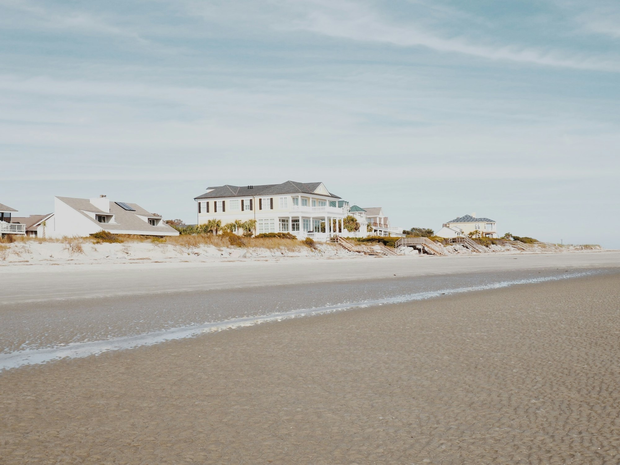 Beachfront homes along a bright sandy shoreline